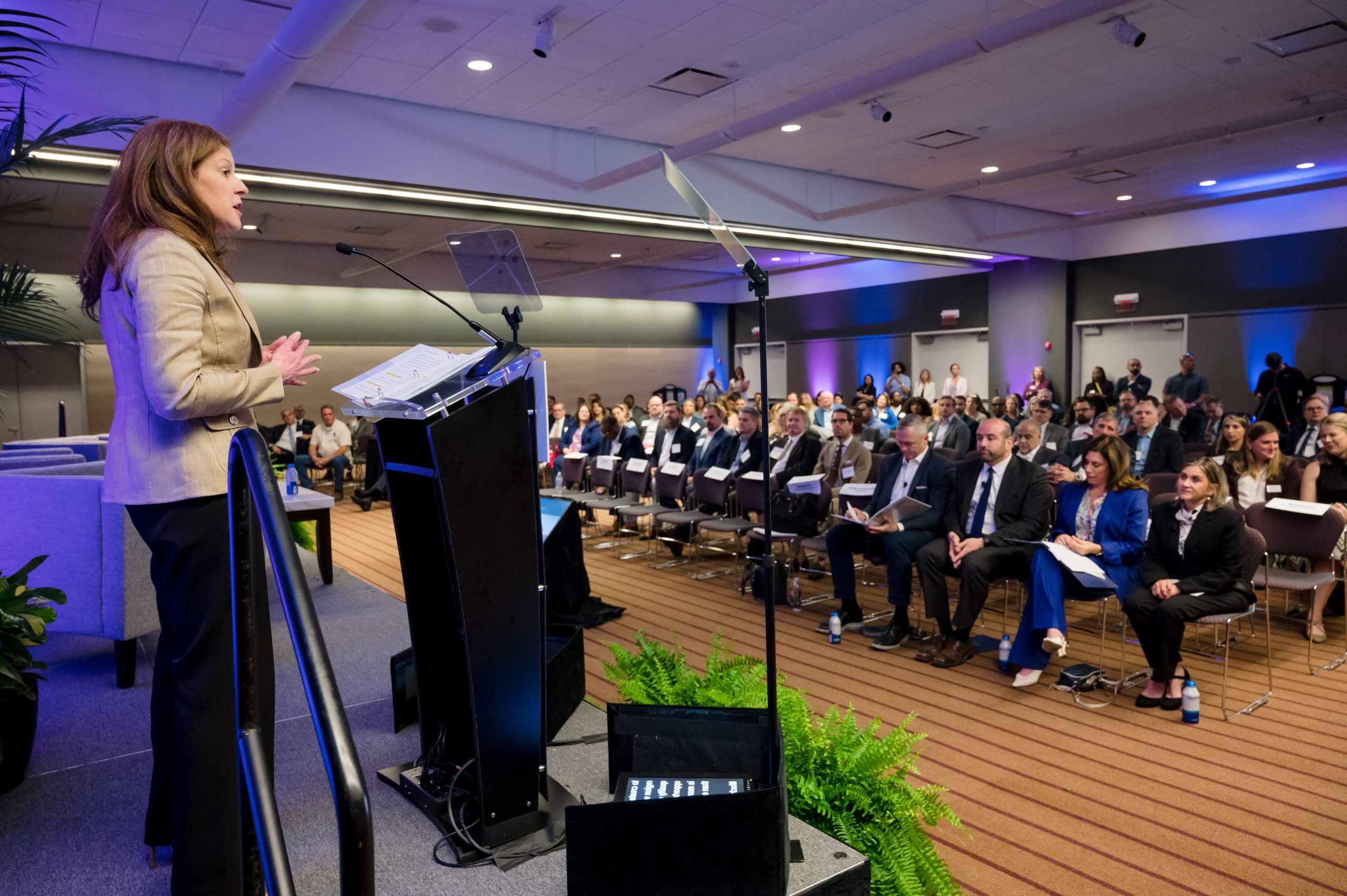 A woman speaking at a podium to a group of people